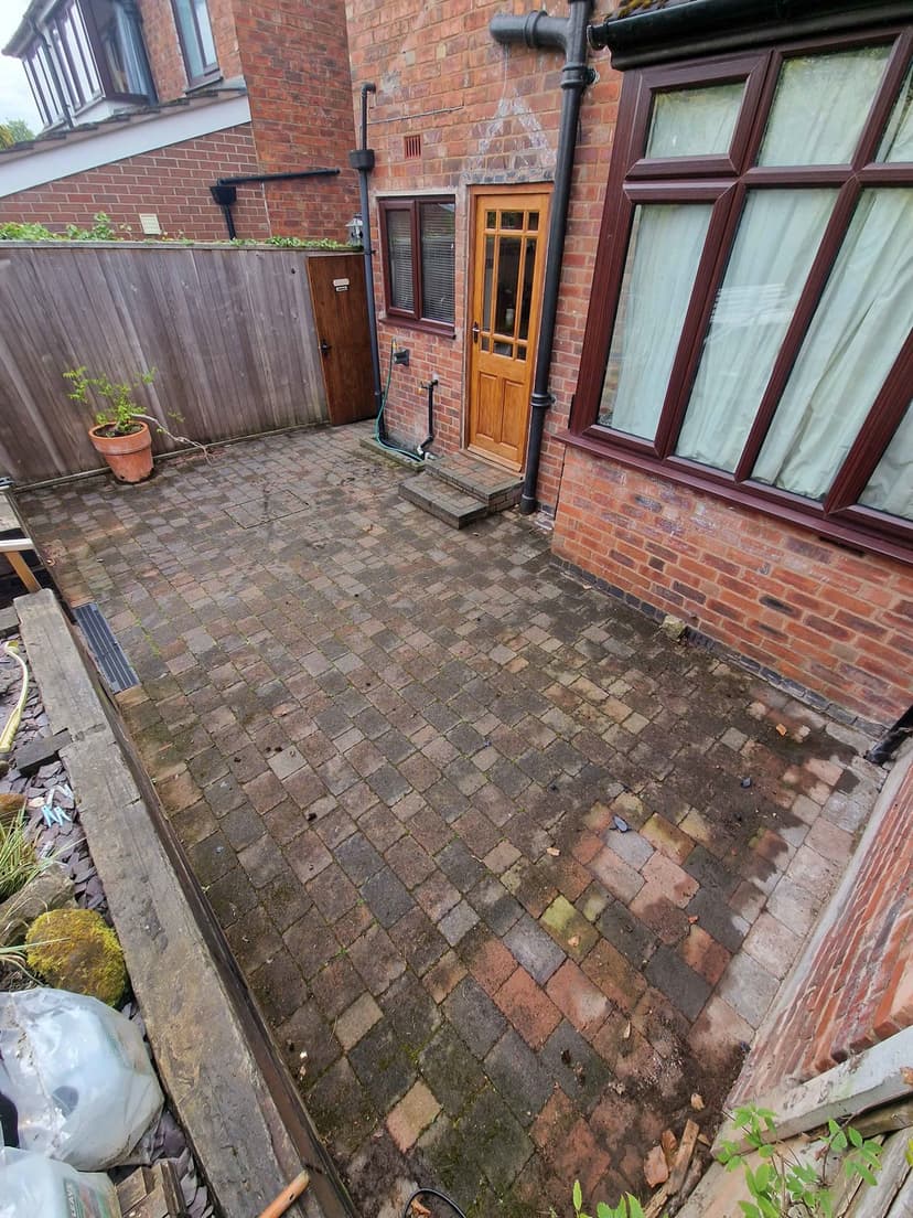 Before — the same courtyard under moss and algae, the colours buried.