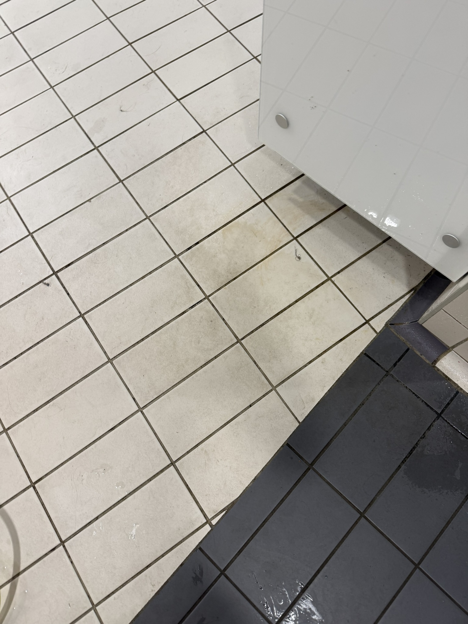 Changing-village floor mid-clean — staining lifting pass by pass.